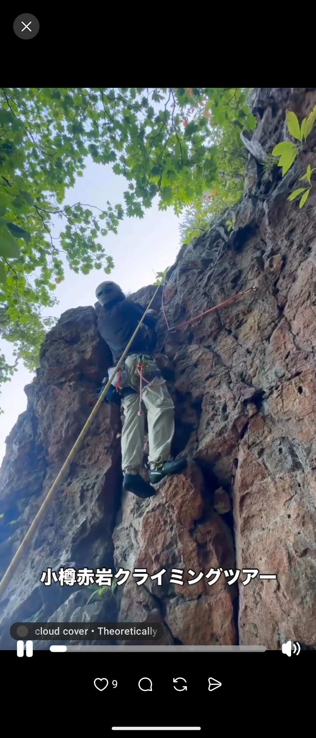 A closer view of a climber using a rope and harness on natural rock.